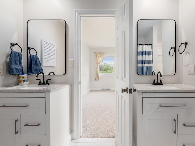 bathroom featuring a sink, baseboards, and two vanities