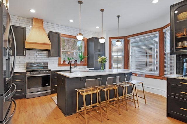 618 Berkeley Rd, Columbus, OH 43205 - kitchen with appliances with stainless steel finishes, custom range hood, light countertops, a kitchen bar, and backsplash