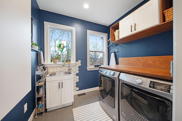 618 Berkeley Rd, Columbus, OH 43205 - laundry room with cabinet space, washing machine and dryer, baseboards, and light tile patterned flooring
