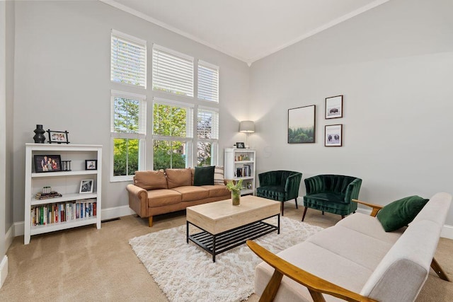 living area featuring crown molding, baseboards, high vaulted ceiling, and light colored carpet