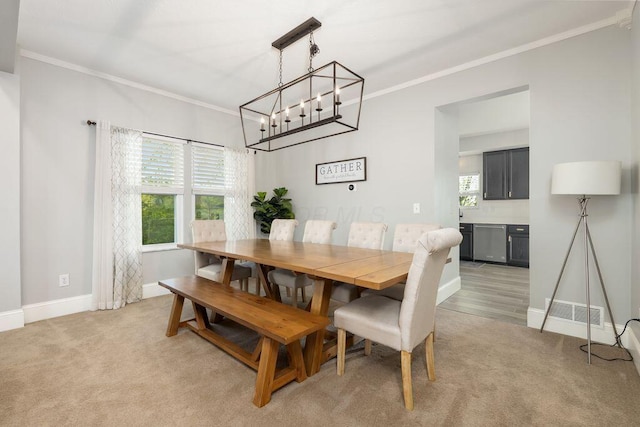 dining space featuring crown molding, baseboards, a notable chandelier, and a wealth of natural light