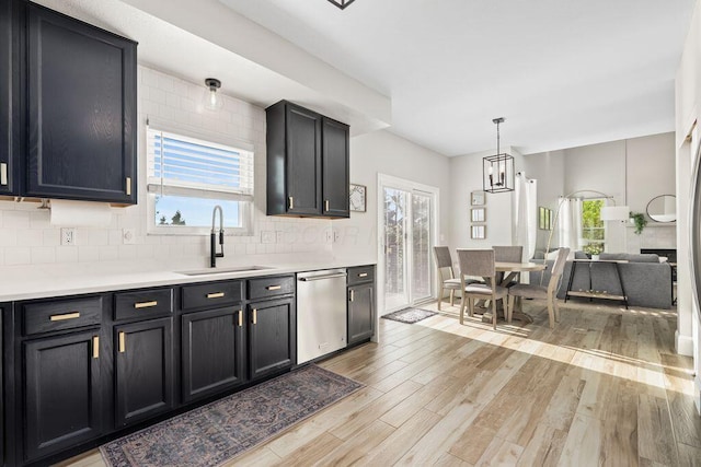 kitchen featuring stainless steel dishwasher, a wealth of natural light, a sink, and light wood-type flooring