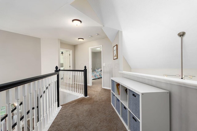 hallway with baseboards, carpet, and an upstairs landing