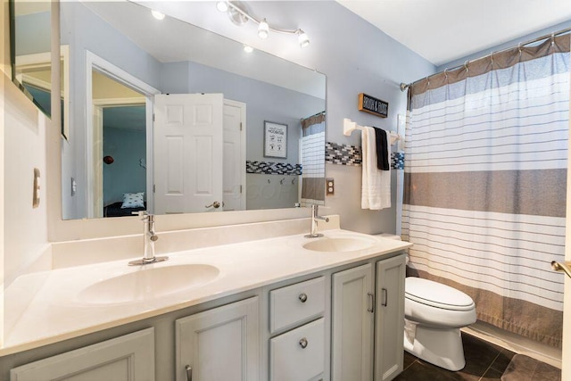 ensuite bathroom with tile patterned flooring, double vanity, toilet, connected bathroom, and a sink