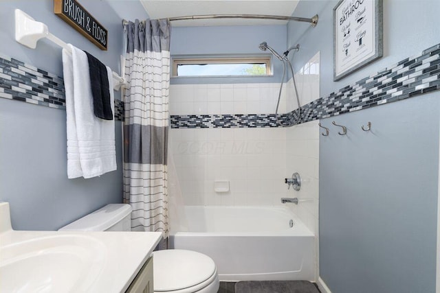 bathroom with toilet, shower / bathtub combination with curtain, and vanity