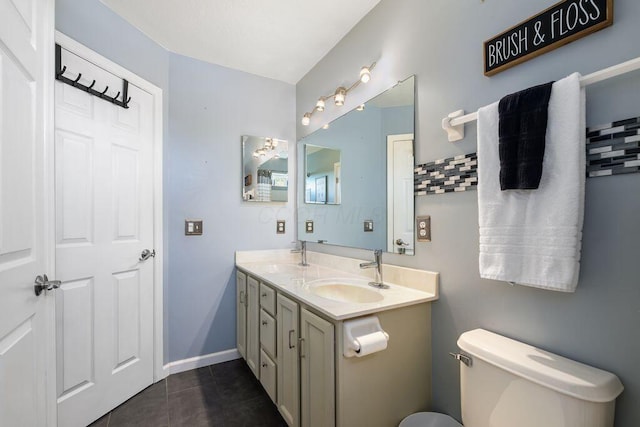 full bath with double vanity, toilet, tile patterned floors, and a sink