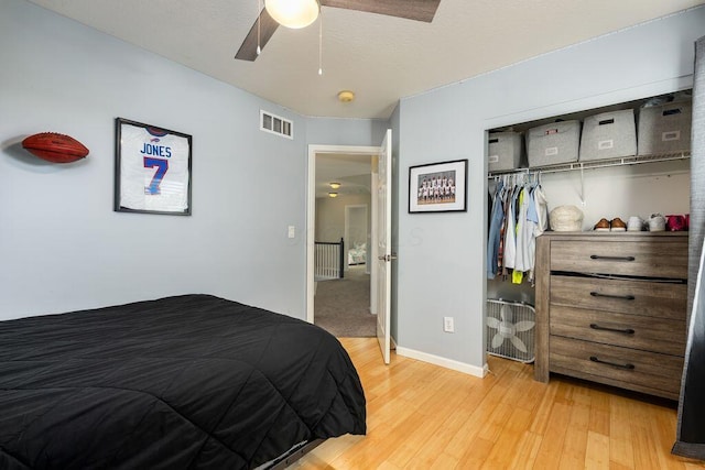 bedroom with visible vents, a closet, baseboards, light wood-type flooring, and a ceiling fan