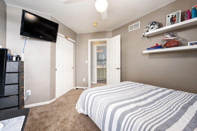 carpeted bedroom with visible vents, baseboards, ceiling fan, and a closet