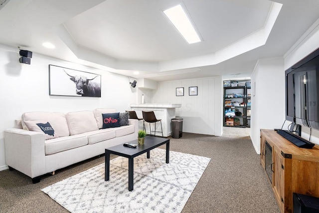 living area with a tray ceiling and carpet