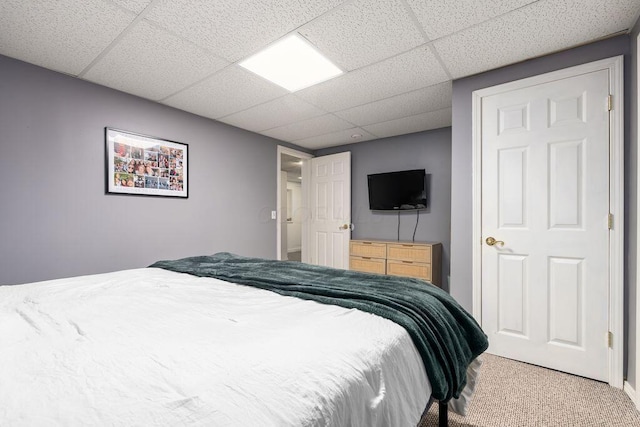 carpeted bedroom with a drop ceiling