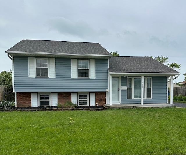 tri-level home featuring covered porch and roof with shingles
