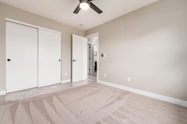 unfurnished bedroom with light carpet, baseboards, and a closet
