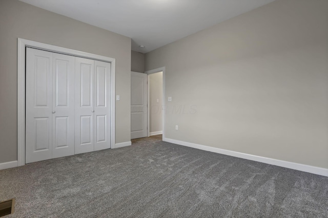 unfurnished bedroom with baseboards, carpet, and a closet