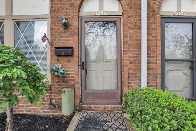 view of exterior entry with brick siding