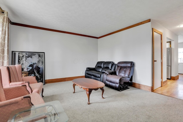 living area with crown molding, baseboards, and light colored carpet