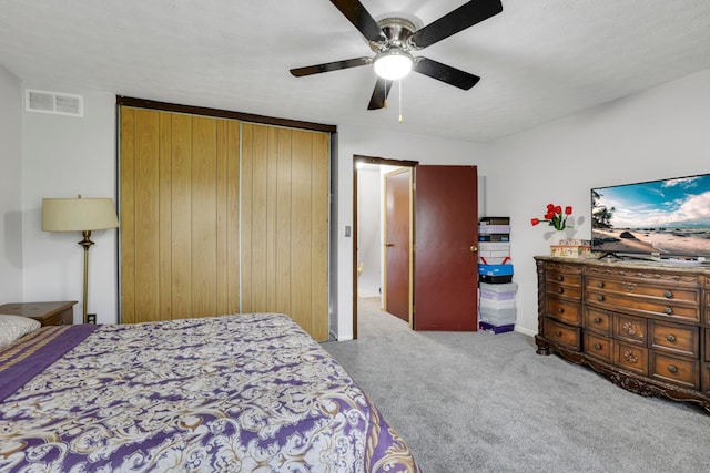 carpeted bedroom with visible vents and a ceiling fan