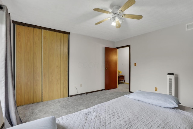 bedroom with a ceiling fan, visible vents, carpet floors, baseboards, and a closet