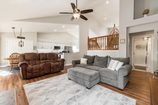 living area with ceiling fan, high vaulted ceiling, baseboards, light wood finished floors, and recessed lighting