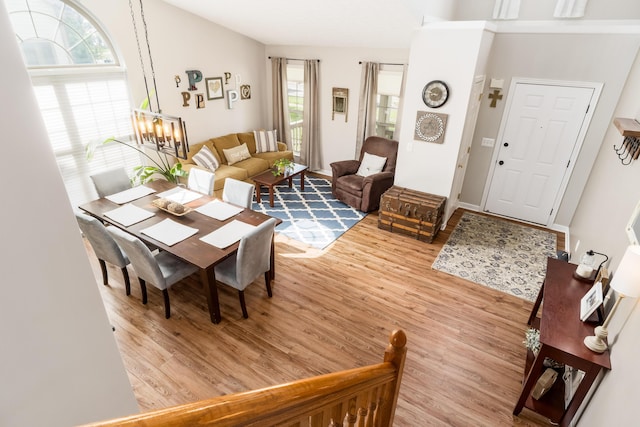 living room with baseboards, an inviting chandelier, and wood finished floors