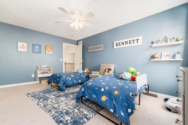carpeted bedroom featuring baseboards, ceiling fan, a textured ceiling, and visible vents