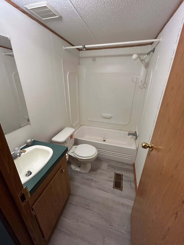 200 Ann St, New Straitsville, OH 43766 - full bathroom featuring wood finished floors, vanity, toilet, bathtub / shower combination, and a textured ceiling