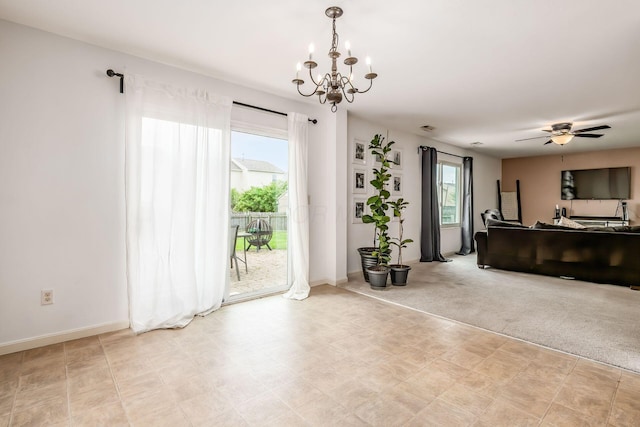 living room featuring baseboards and ceiling fan with notable chandelier