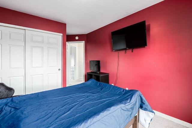 bedroom featuring carpet floors, baseboards, and a closet
