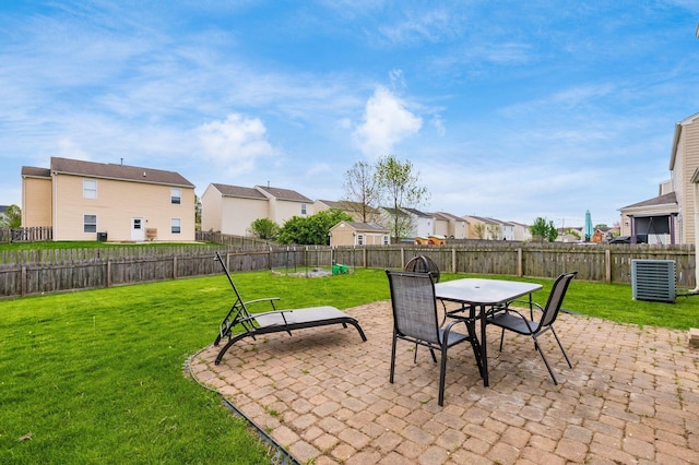 view of patio / terrace featuring central AC, a residential view, a fenced backyard, and outdoor dining space