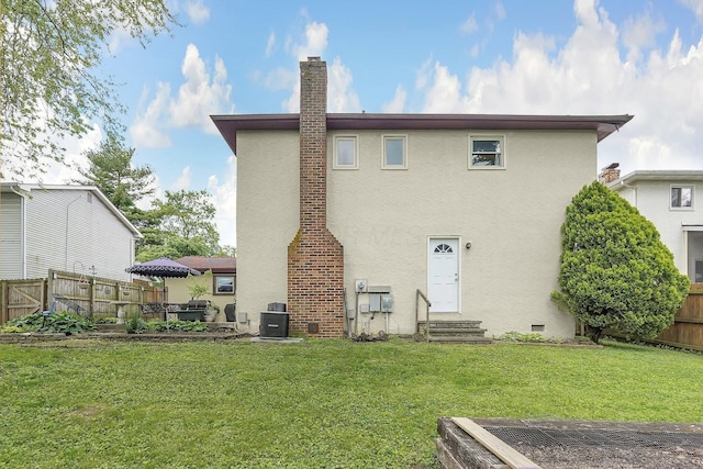 5968 Lisa St, Columbus, OH 43231 - rear view of house featuring entry steps, stucco siding, a chimney, and cooling unit
