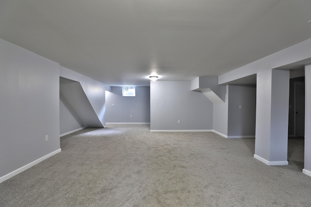 below grade area featuring baseboards and carpet flooring
