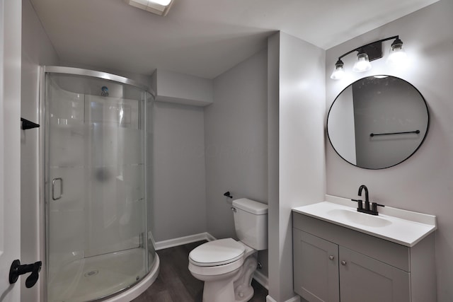 bathroom featuring wood finished floors, baseboards, a stall shower, and toilet