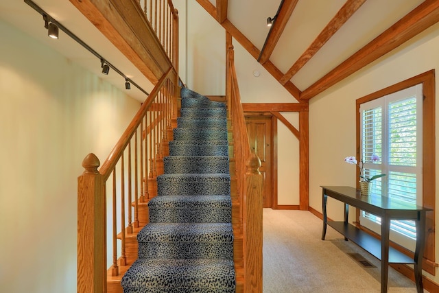 staircase with carpet flooring, track lighting, baseboards, beamed ceiling, and visible vents