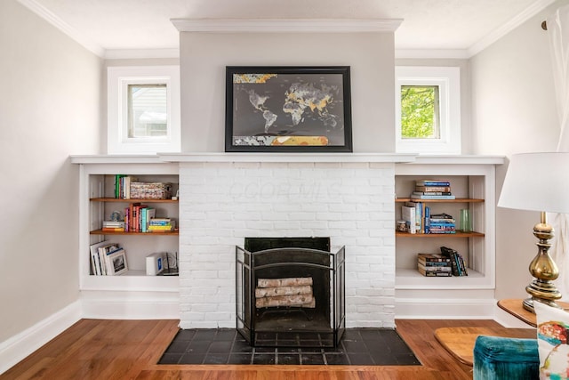 living area featuring crown molding, baseboards, a fireplace, and wood finished floors