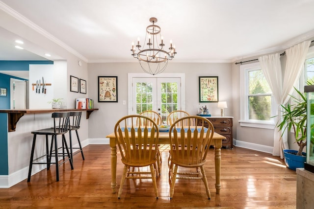 dining room with baseboards, a chandelier, a healthy amount of sunlight, and wood finished floors