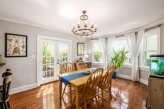 dining room with an inviting chandelier, french doors, baseboards, ornamental molding, and hardwood / wood-style flooring
