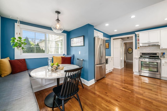 dining area featuring baseboards, recessed lighting, light wood-style flooring, and breakfast area