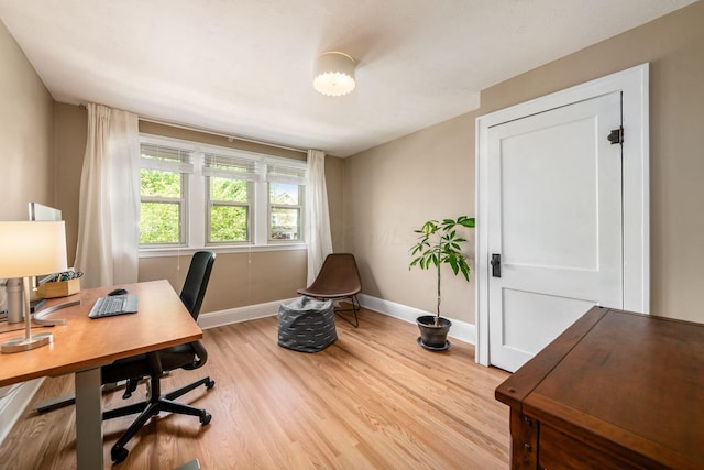 office area featuring baseboards and light wood-type flooring