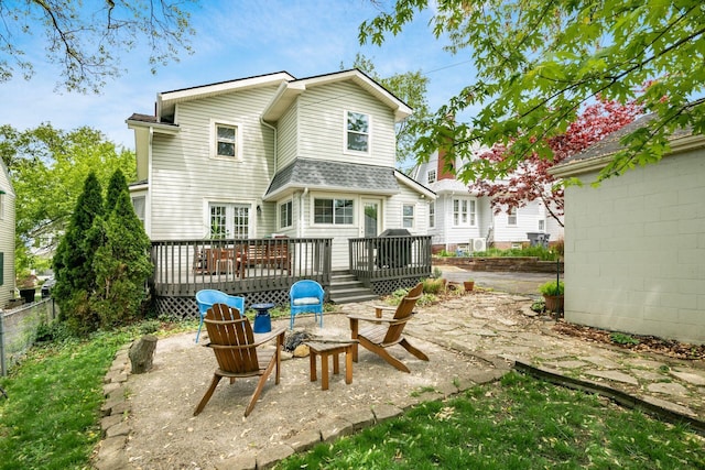 back of property featuring a deck, fence, a patio area, and an outdoor fire pit