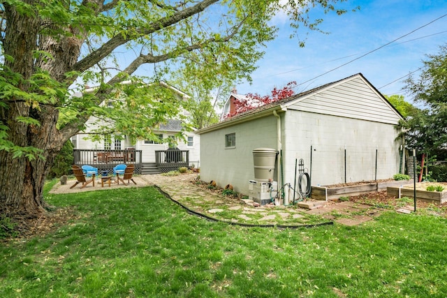 rear view of property featuring a lawn, a deck, and a chimney
