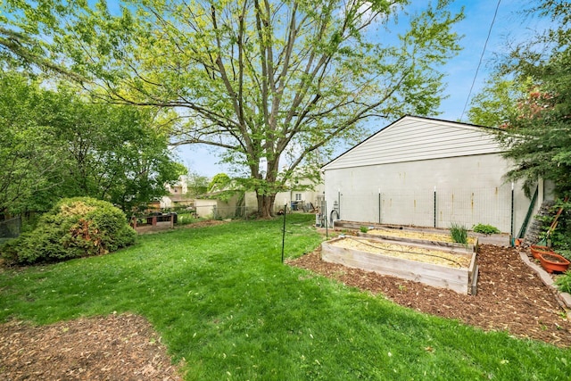 view of yard featuring fence and a vegetable garden
