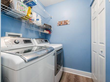 clothes washing area with laundry area, dark wood-type flooring, baseboards, and independent washer and dryer