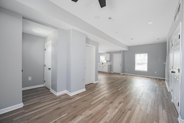 331 E Barthman Ave, Columbus, OH 43207 - unfurnished living room featuring a sink, baseboards, light wood finished floors, and visible vents