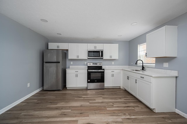 331 E Barthman Ave, Columbus, OH 43207 - kitchen with light wood-type flooring, light countertops, white cabinets, and stainless steel appliances
