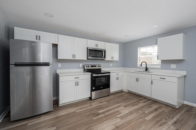 331 E Barthman Ave, Columbus, OH 43207 - kitchen with light countertops, white cabinets, appliances with stainless steel finishes, and a sink