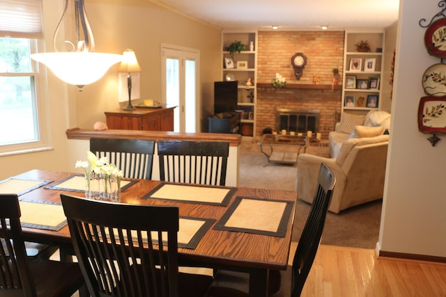 10160 Wellington Dr, Pickerington, OH 43147 - dining space featuring wood finished floors, plenty of natural light, built in features, and a fireplace