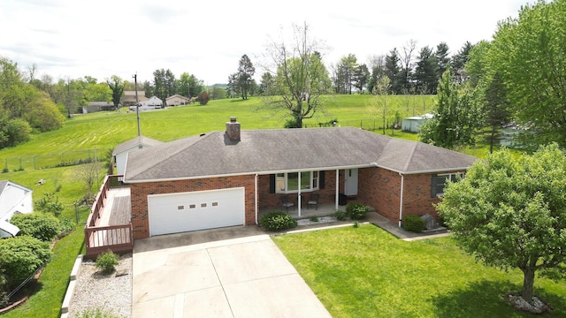ranch-style home featuring brick siding, a front lawn, an attached garage, and driveway
