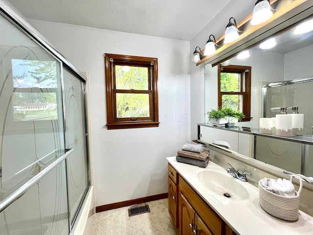 full bath with plenty of natural light, a shower with door, visible vents, and vanity