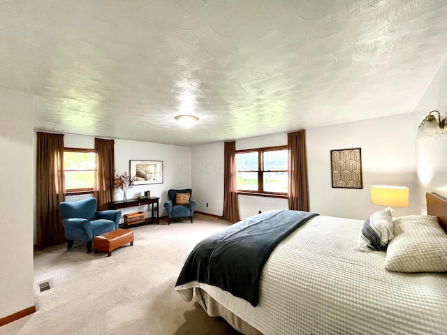 carpeted bedroom featuring baseboards, a textured ceiling, and visible vents