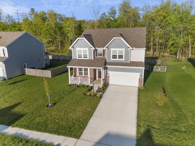 traditional-style house with fence, covered porch, brick siding, concrete driveway, and an attached garage