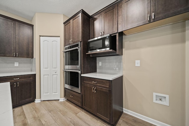 kitchen with appliances with stainless steel finishes, baseboards, dark brown cabinetry, and light wood-type flooring